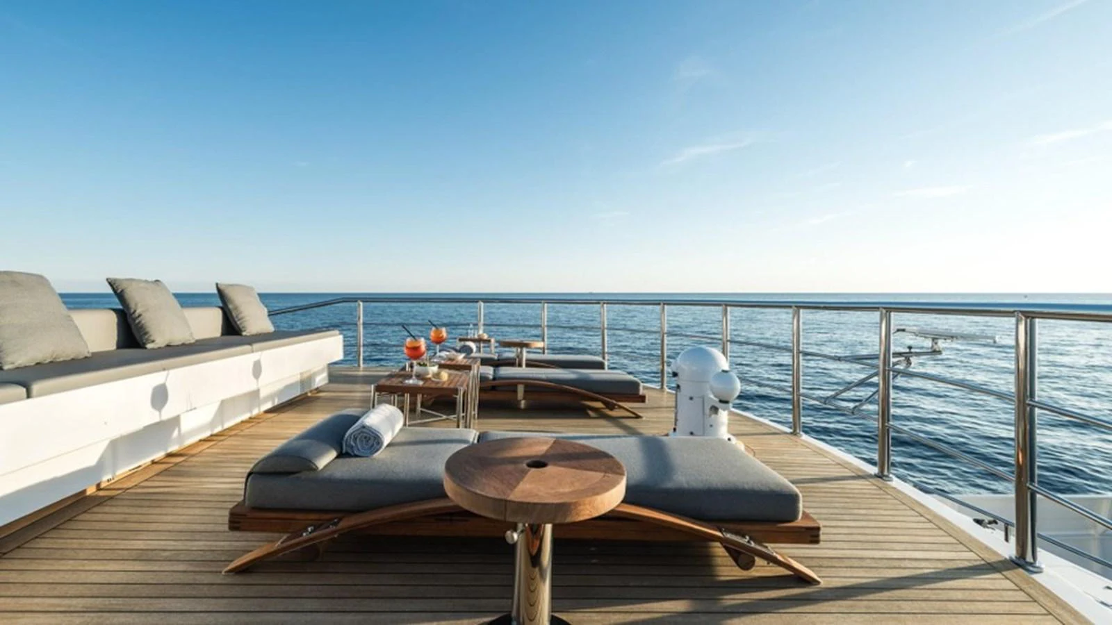 The sundeck offers a serene space with luxurious sun loungers and a stunning ocean view. aboard R23 Yacht for Sale