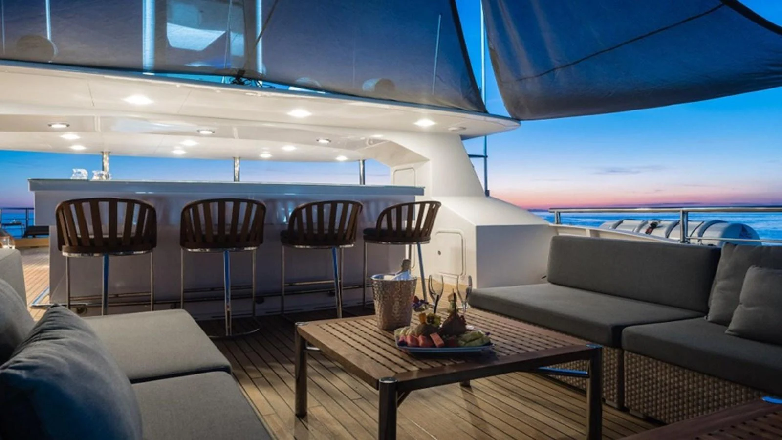 The aft deck features a stylish bar area with comfortable seating and a stunning ocean view. aboard R23 Yacht for Sale