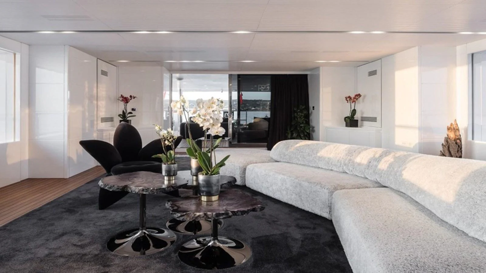 The yacht's salon features modern furnishings with a plush sectional sofa and elegant decor. aboard R23 Yacht for Sale
