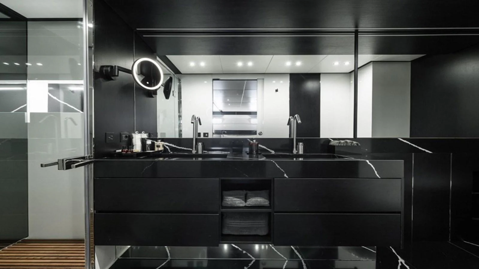 A sleek and modern yacht bathroom with black marble finishes and contemporary fixtures. aboard R23 Yacht for Sale