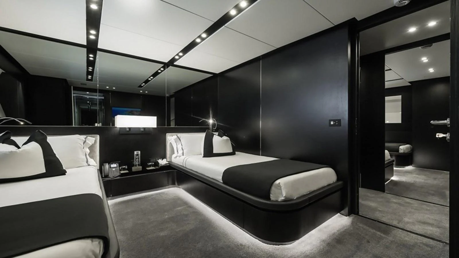 A sleek and modern twin stateroom with luxurious black and white decor. aboard R23 Yacht for Sale