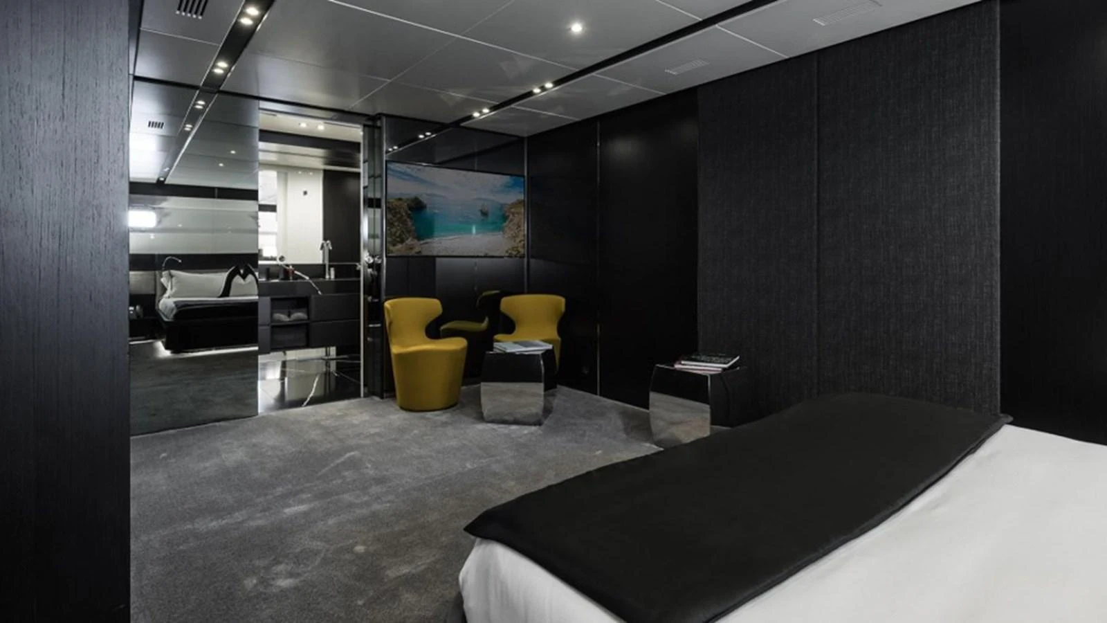 The master stateroom features a modern design with dark walls, plush carpeting, and contemporary furnishings. aboard R23 Yacht for Sale