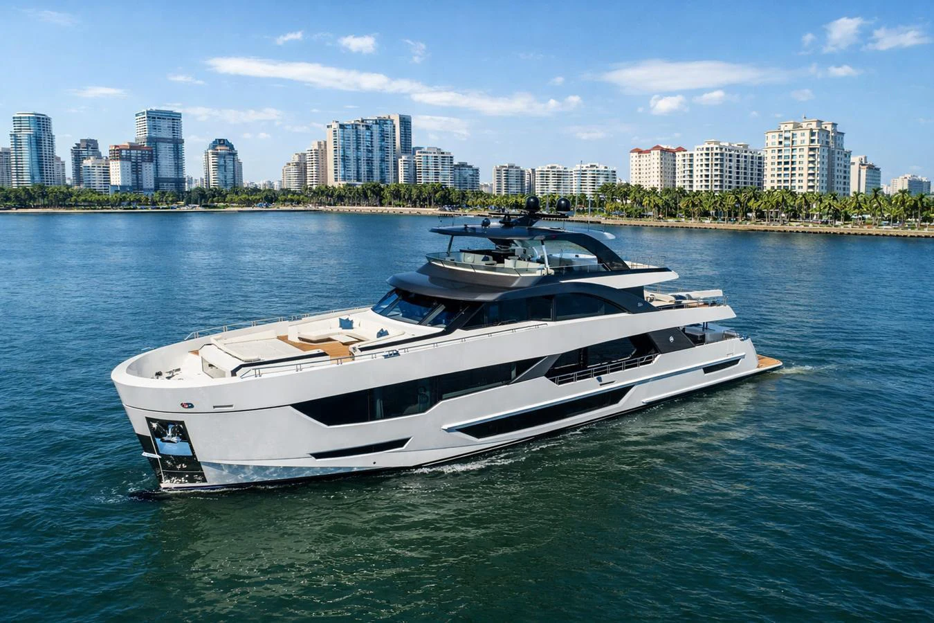 A sleek and modern yacht cruises through calm waters with a cityscape in the background. aboard SERENITY NOW Yacht for Sale
