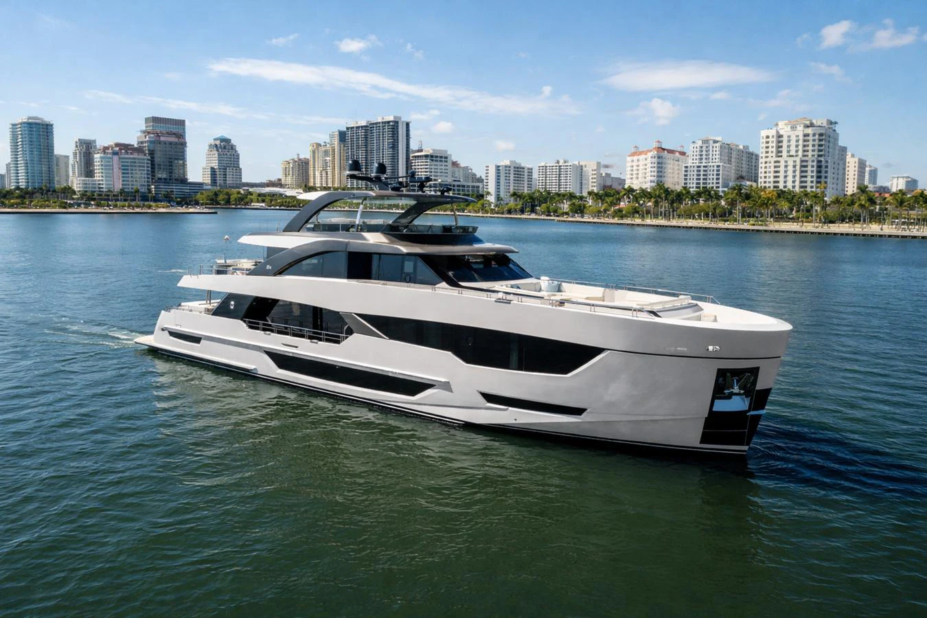 A sleek, modern yacht cruises along the waterfront with a city skyline in the background. aboard SERENITY NOW Yacht for Sale