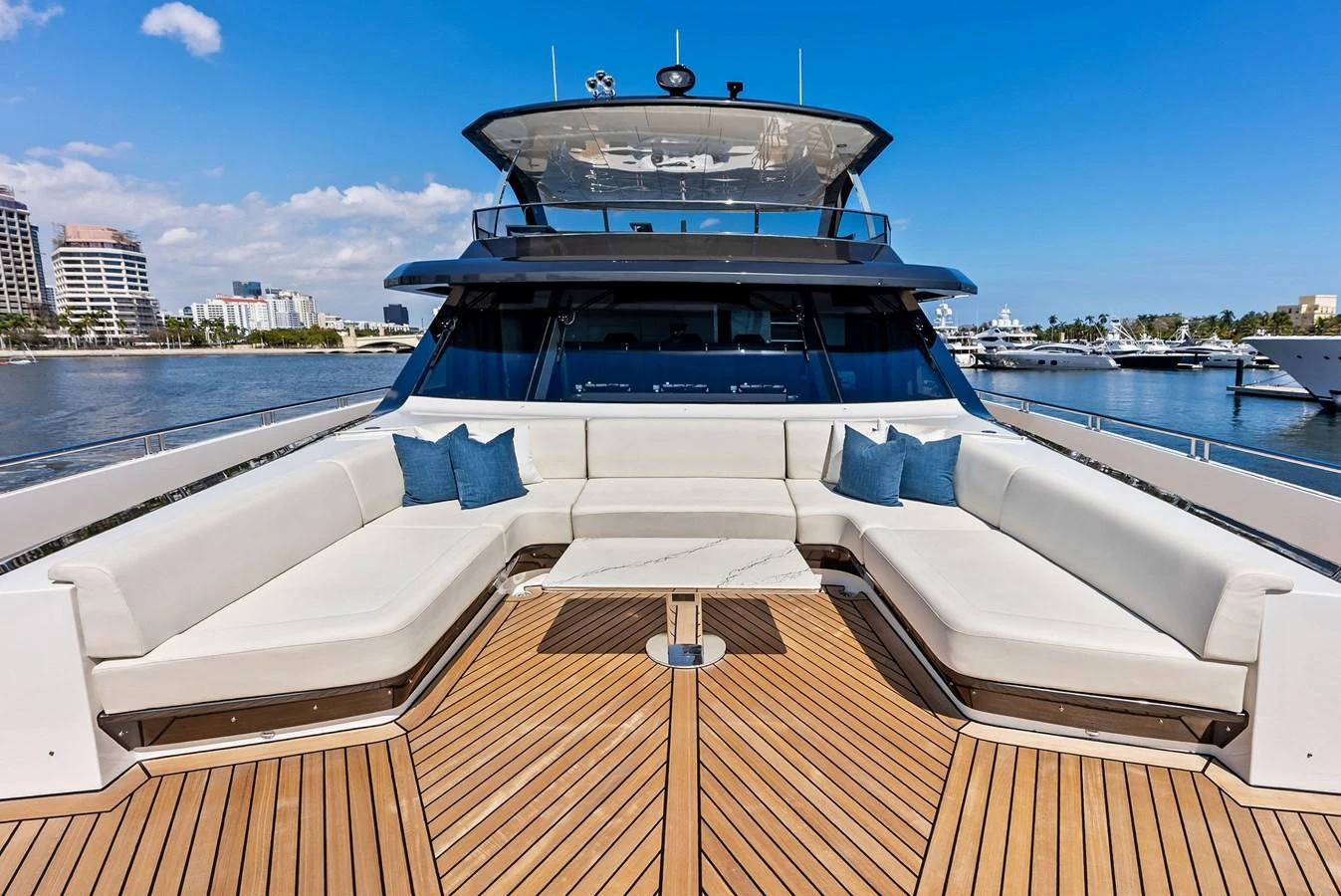 The yacht features a spacious bow seating area with luxurious cushions and a stunning view of the marina. aboard SERENITY NOW Yacht for Sale