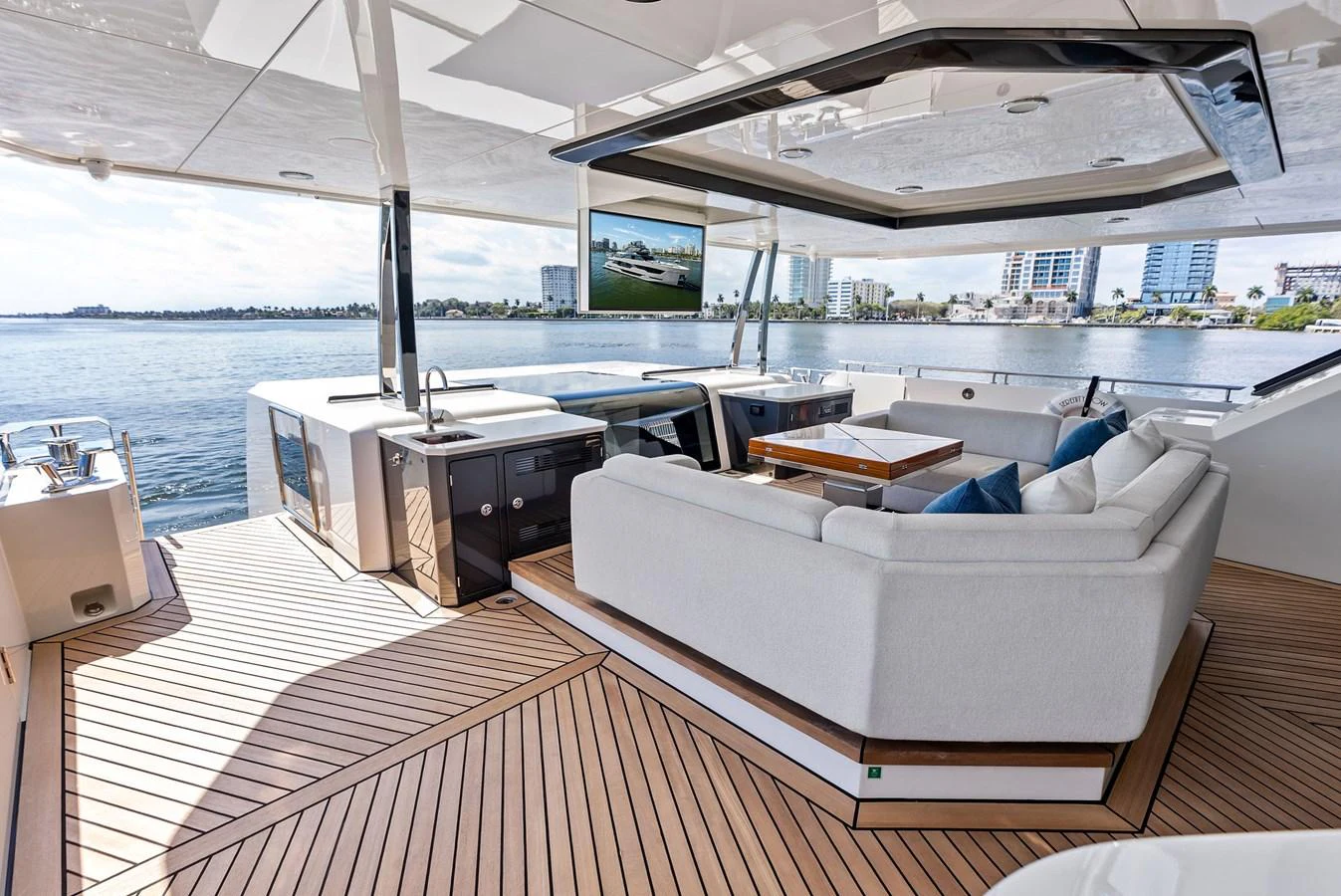 The aft deck features a luxurious seating area with a large TV and stunning views of the water. aboard SERENITY NOW Yacht for Sale