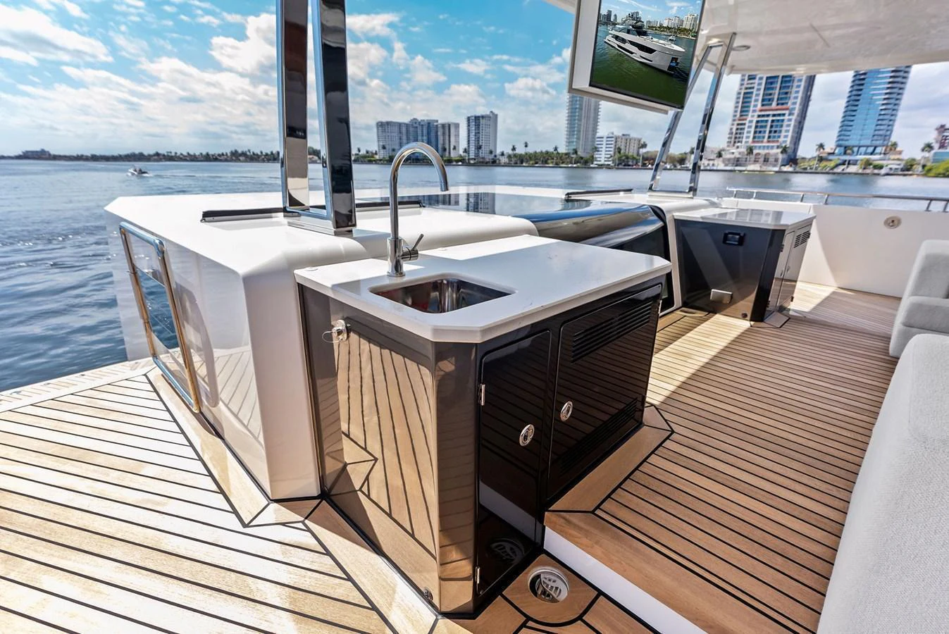 The yacht features a sleek outdoor galley with modern appliances and a stunning waterfront view. aboard SERENITY NOW Yacht for Sale
