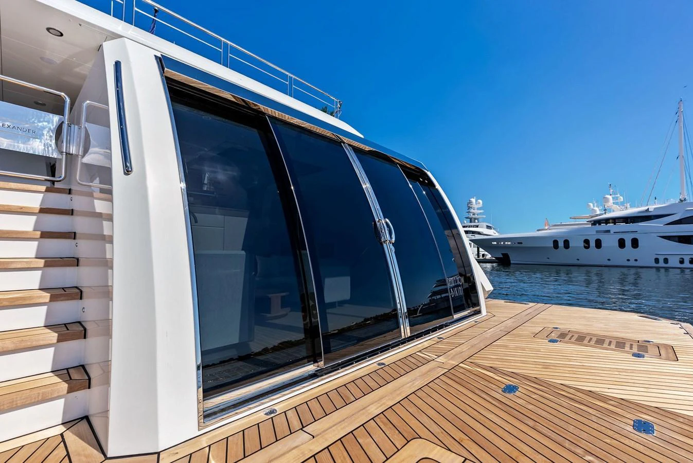 The yacht features a sleek exterior with large glass doors and a spacious deck area. aboard SERENITY NOW Yacht for Sale