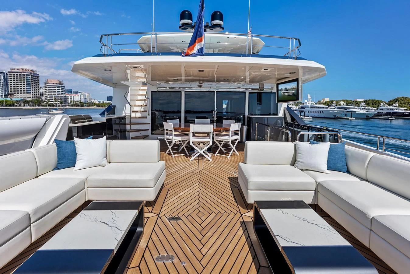 The aft deck offers a spacious and luxurious outdoor seating area with modern furnishings and a stunning view of the marina. aboard SERENITY NOW Yacht for Sale
