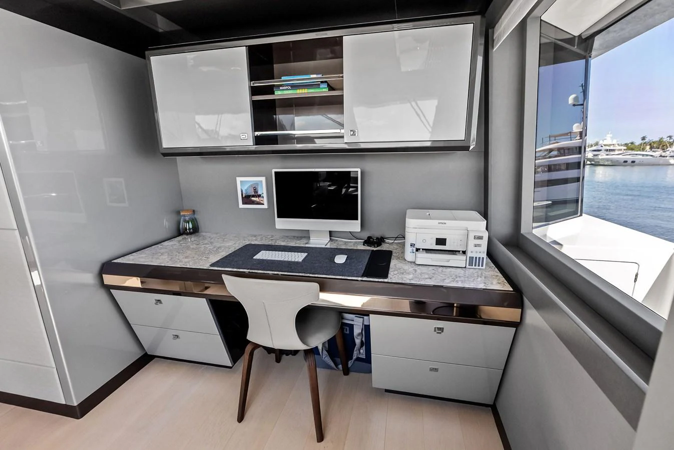 This yacht features a sleek and modern office space with a view of the water. aboard SERENITY NOW Yacht for Sale