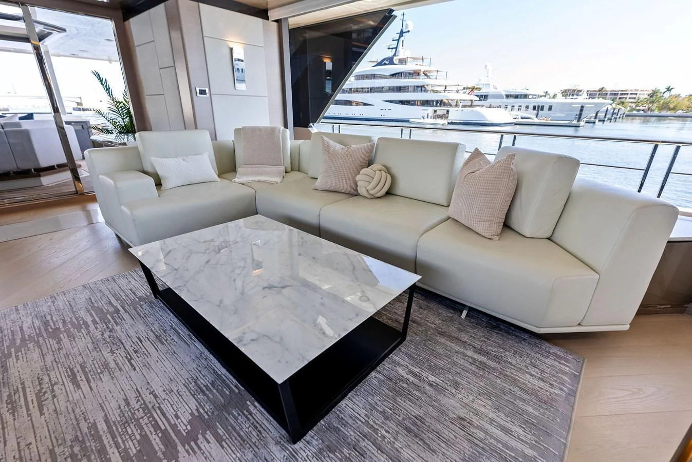 The salon features a luxurious seating area with a modern marble coffee table and elegant decor. aboard SERENITY NOW Yacht for Sale