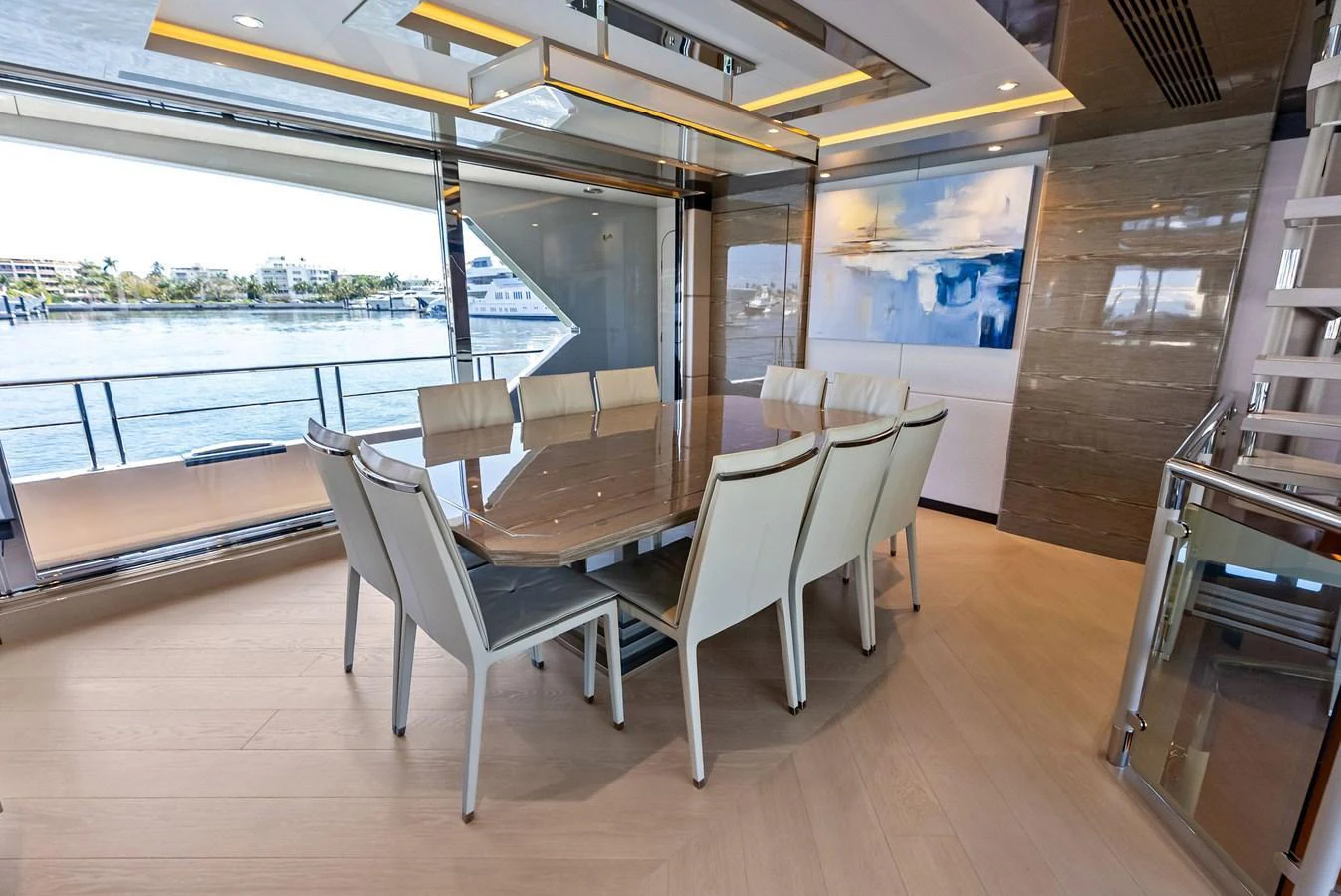 The yacht's dining area features a sleek table with comfortable seating and large windows offering stunning water views. aboard SERENITY NOW Yacht for Sale