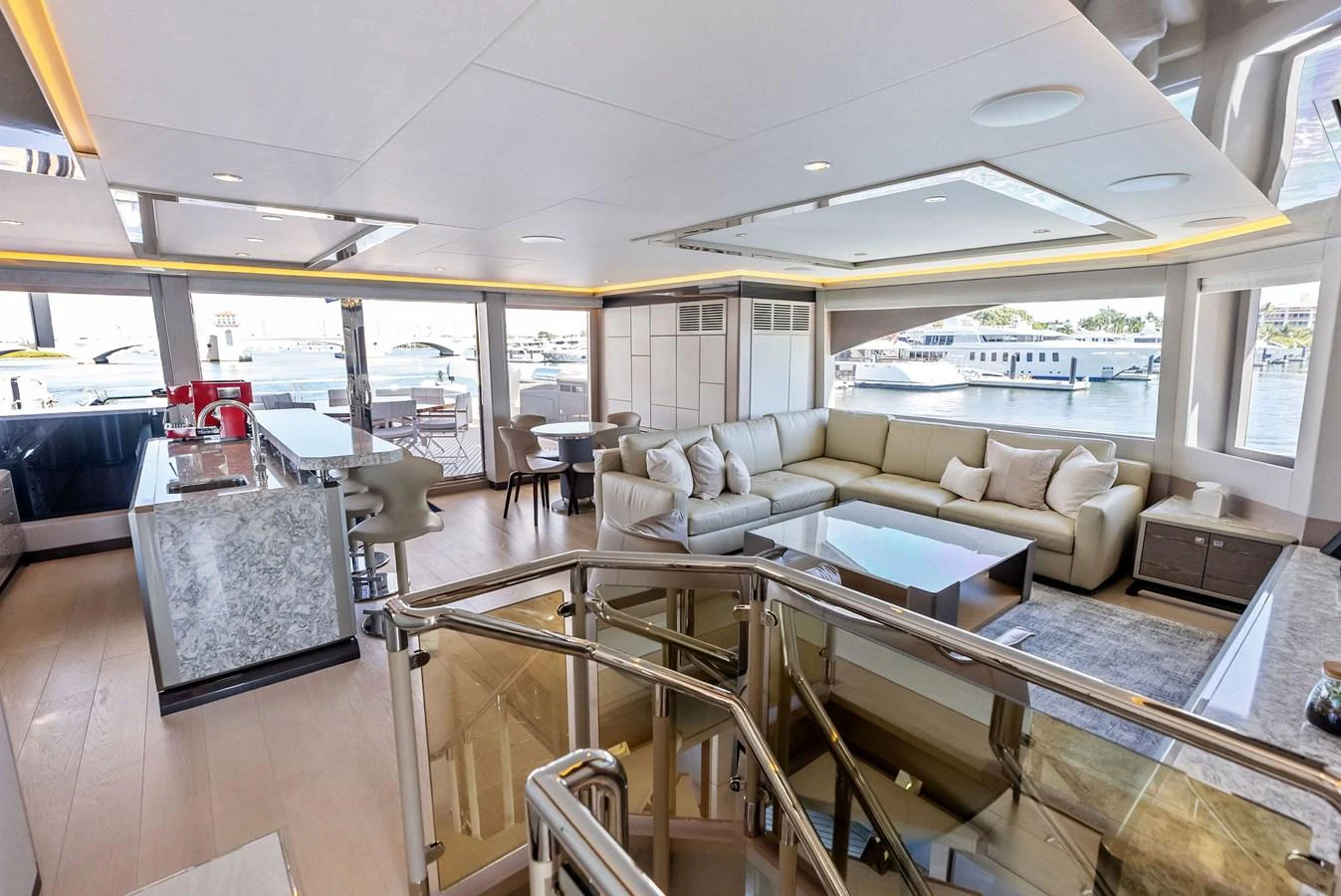 The spacious salon features modern furnishings and ample natural light with views of the marina. aboard SERENITY NOW Yacht for Sale