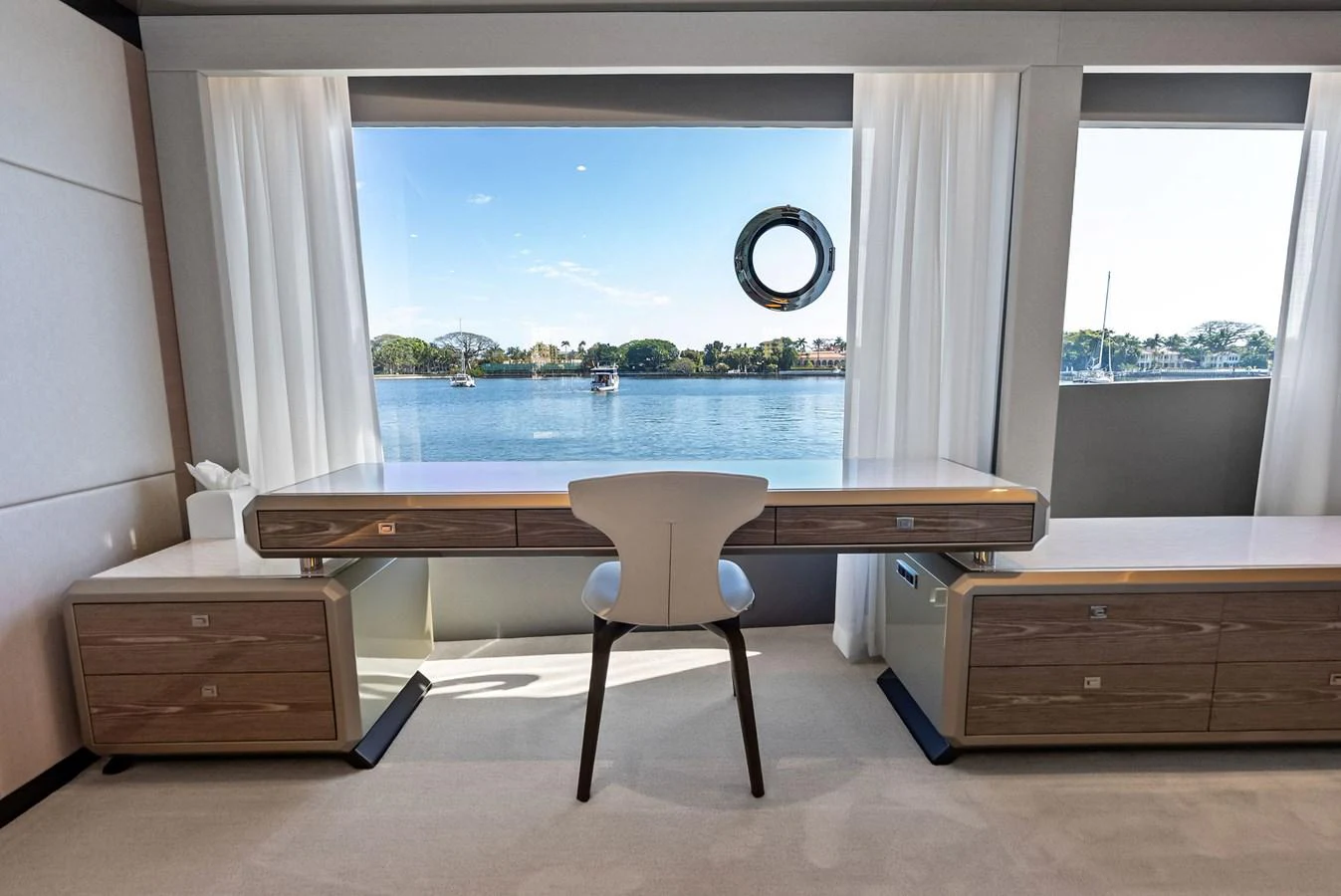 A serene office space with a large window offering a stunning view of the water. aboard SERENITY NOW Yacht for Sale