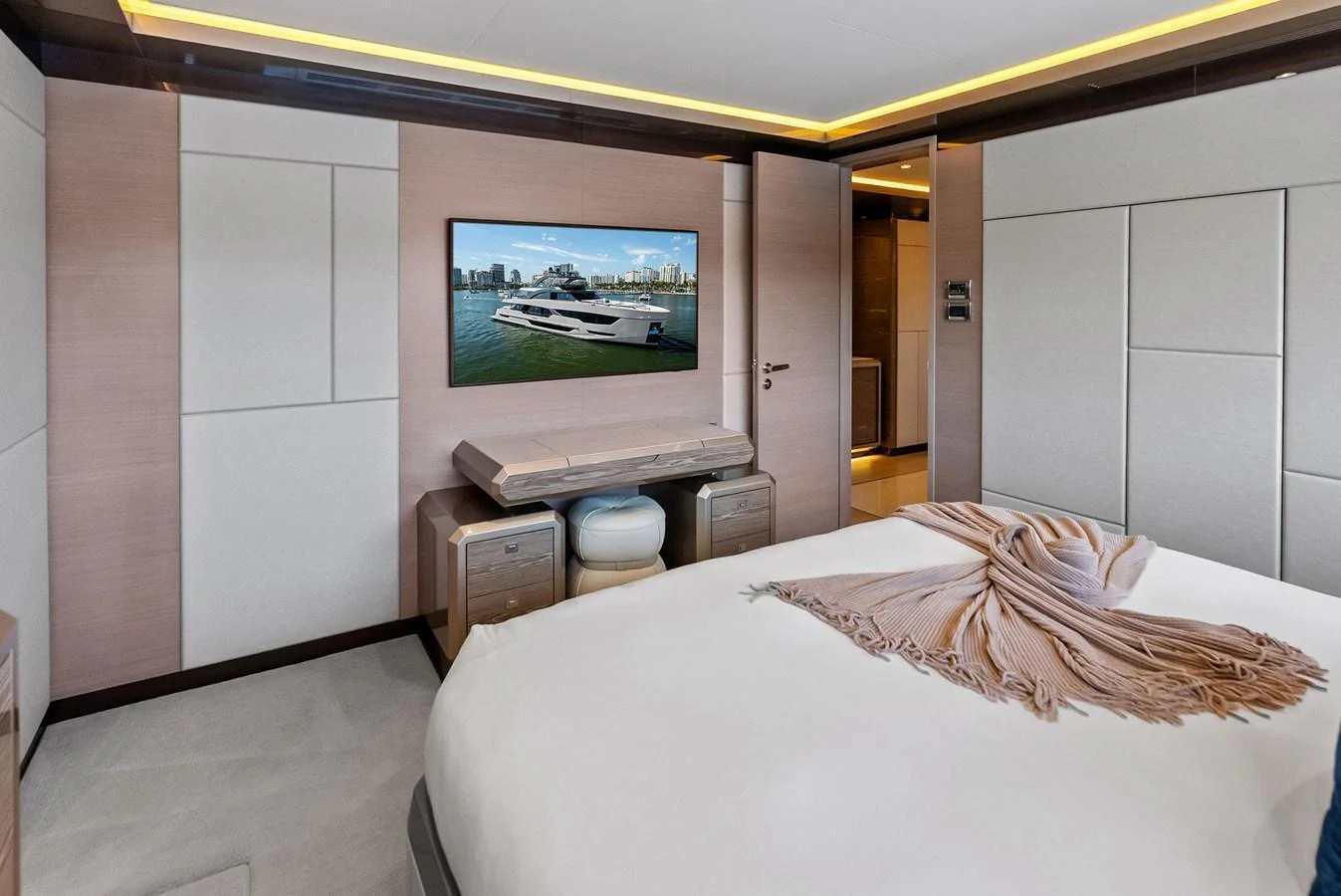 A luxurious stateroom featuring a large bed, modern decor, and a flat-screen TV. aboard SERENITY NOW Yacht for Sale