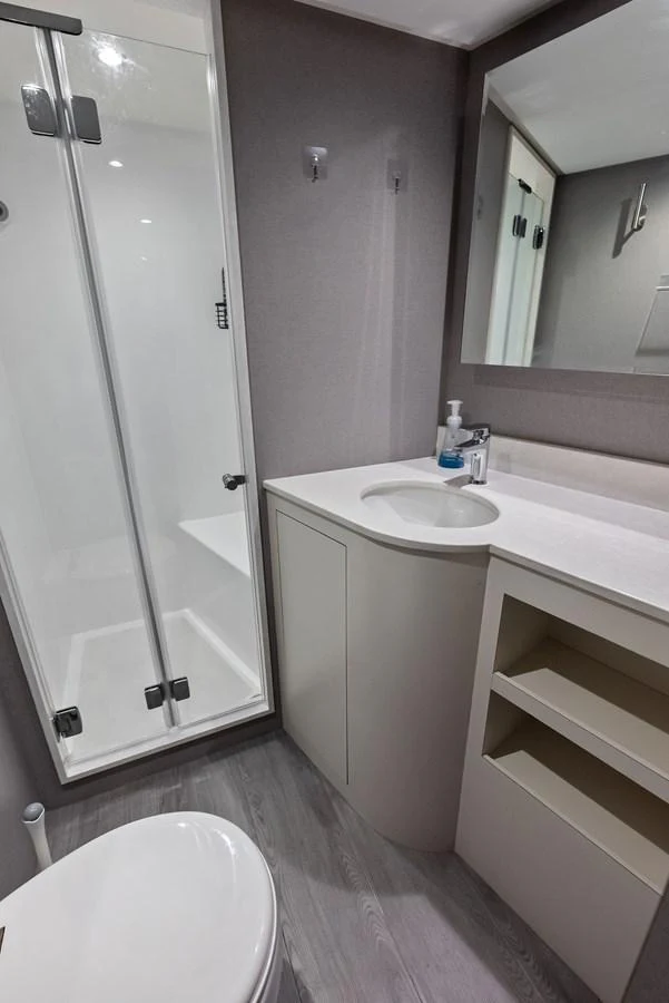 A modern yacht bathroom with a sleek shower and vanity area. aboard SERENITY NOW Yacht for Sale