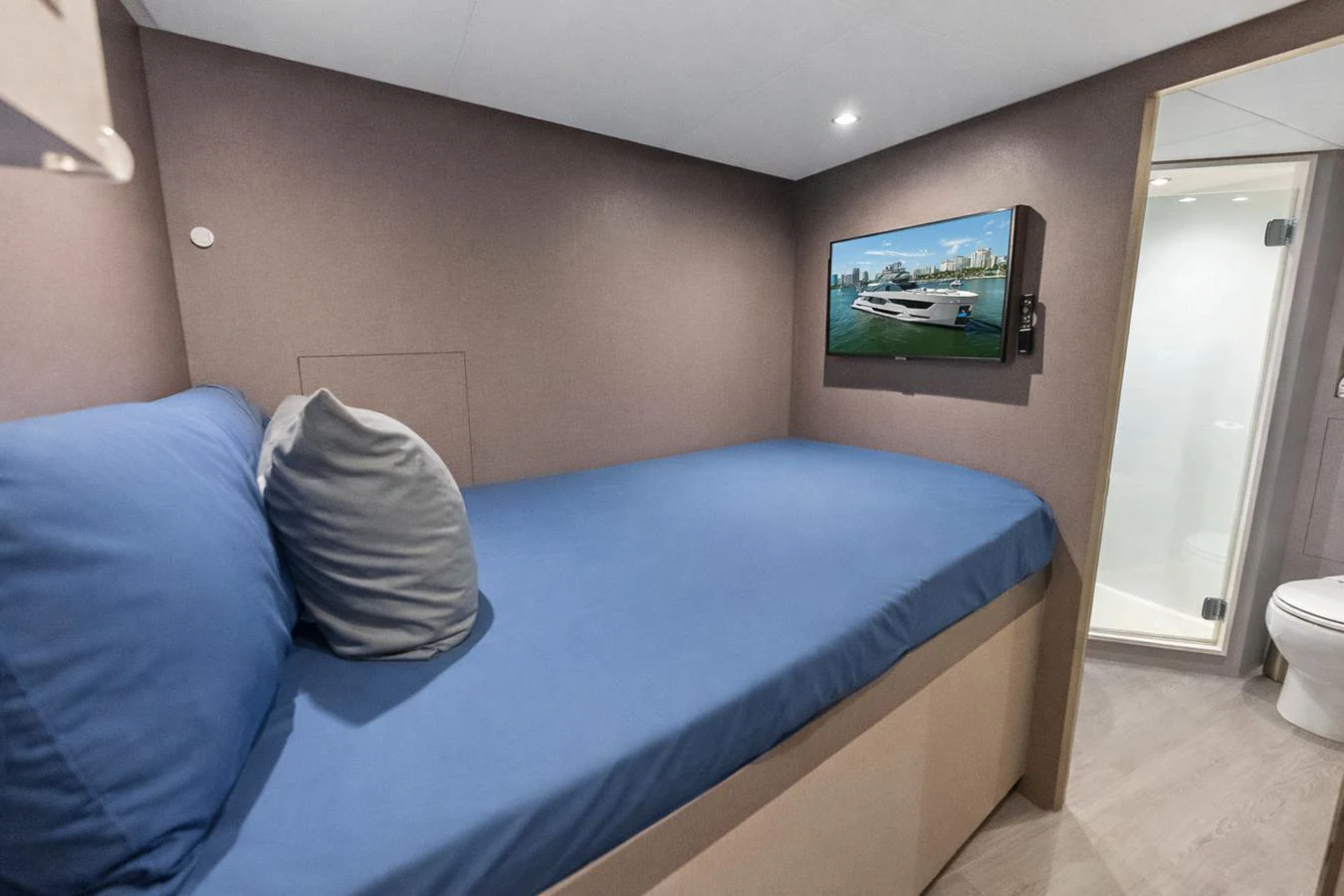 A cozy guest cabin featuring a comfortable bed and a wall-mounted TV. aboard SERENITY NOW Yacht for Sale