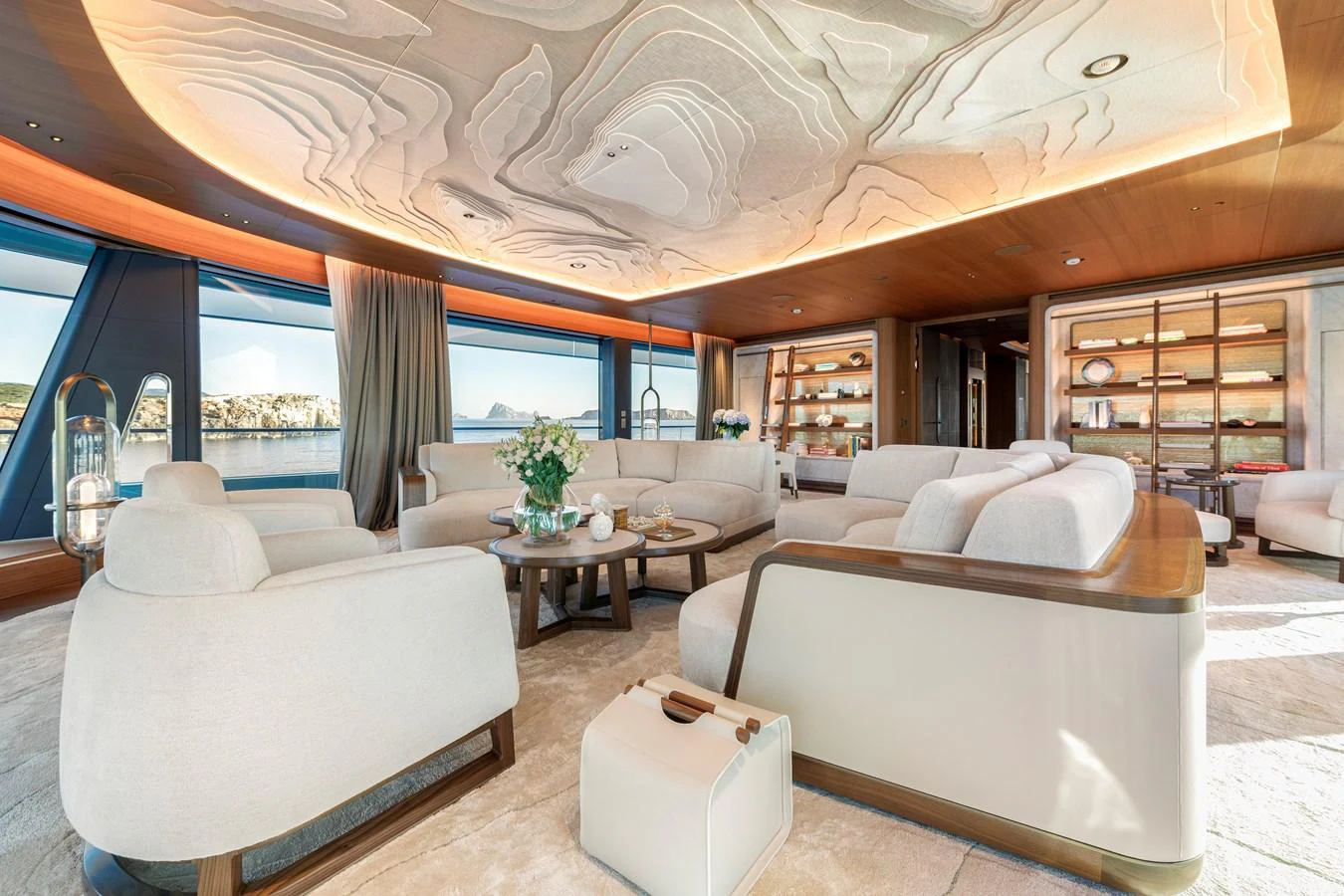 The salon features luxurious seating with elegant decor and expansive windows offering stunning views. aboard KENSHO Yacht for Sale