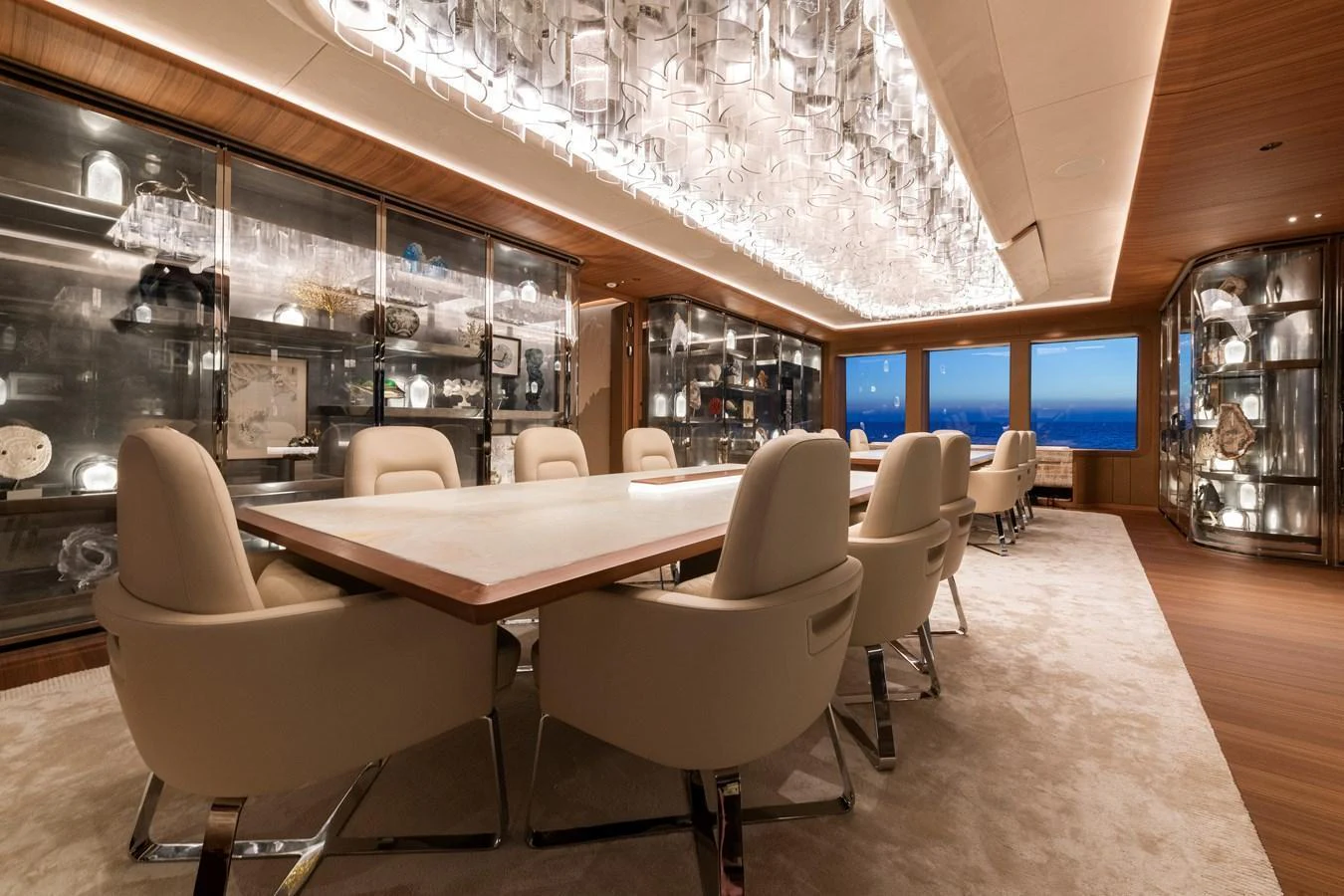 The yacht's dining room features a luxurious setting with elegant seating and a stunning ceiling light fixture. aboard KENSHO Yacht for Sale