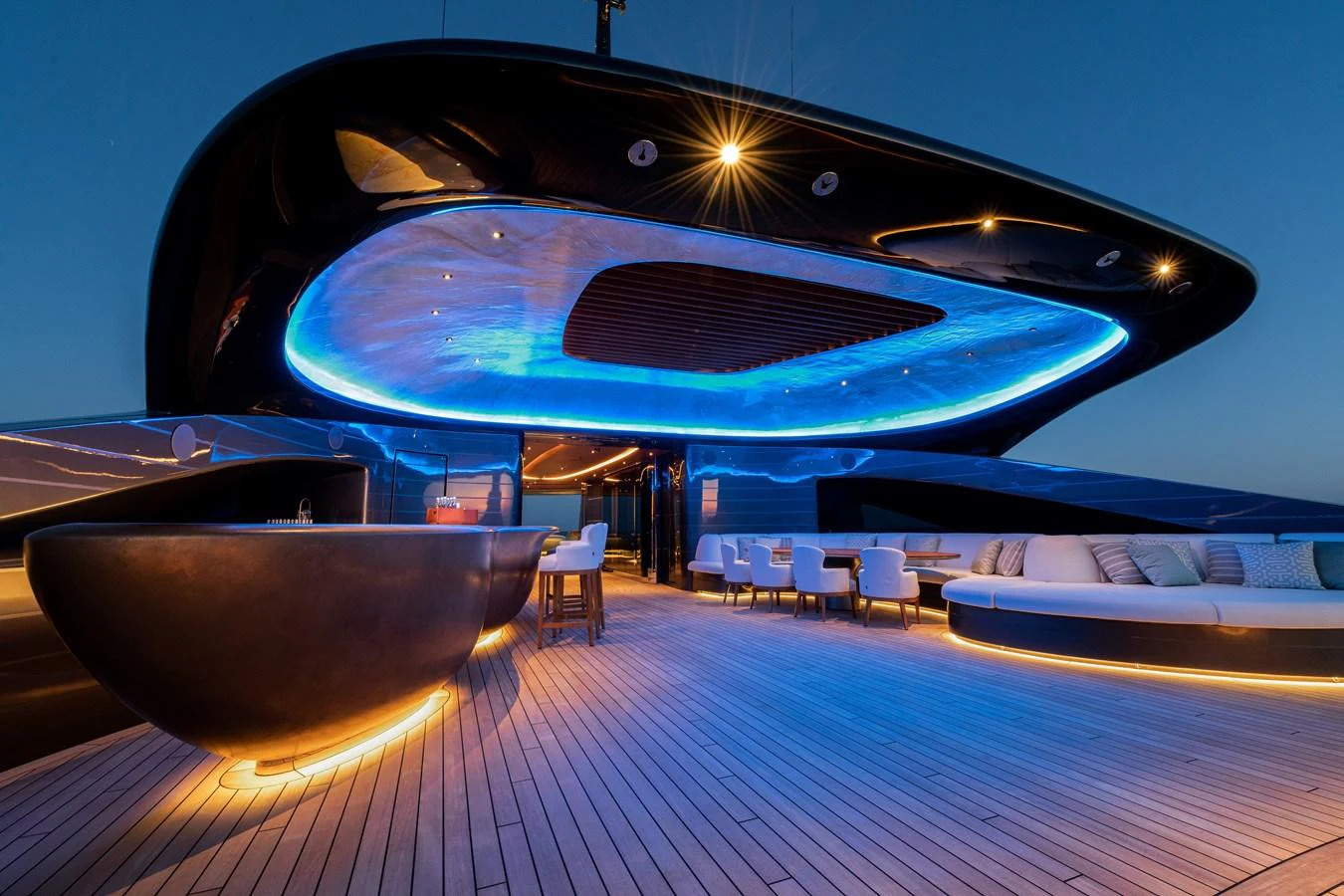 The aft deck features a sleek, modern design with ambient lighting and luxurious seating. aboard KENSHO Yacht for Sale