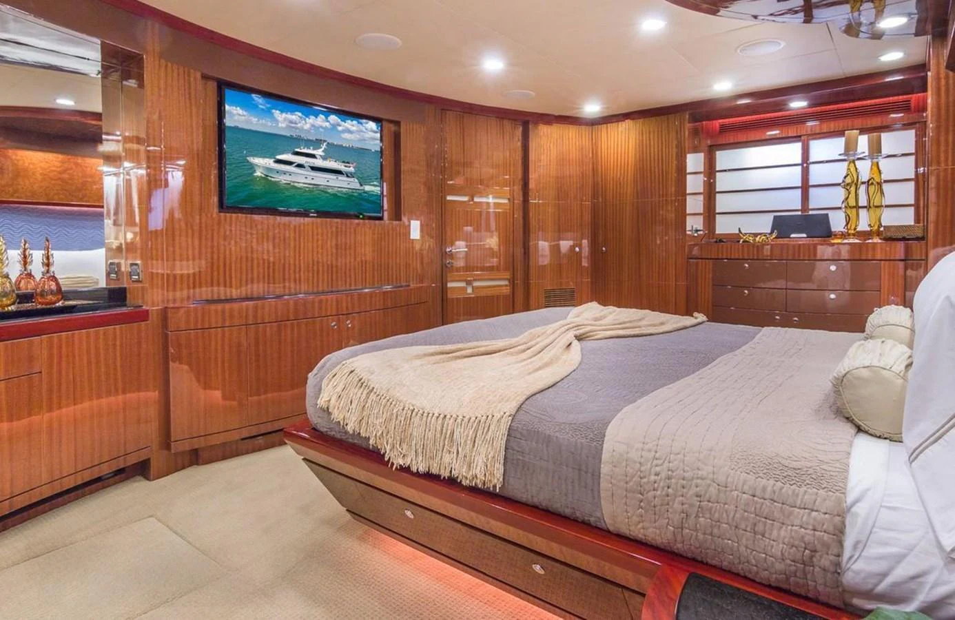 The master stateroom features a luxurious bed, rich wood paneling, and a flat-screen TV. aboard ROBIN'S NEST Yacht for Sale