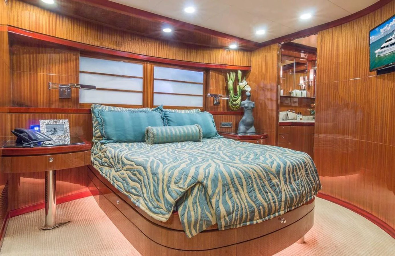 The stateroom features a luxurious bed with elegant bedding and warm wood paneling. aboard ROBIN'S NEST Yacht for Sale