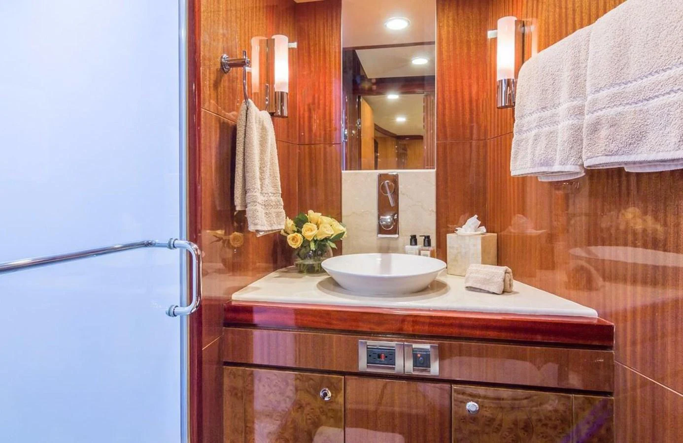 The yacht's bathroom features elegant wood paneling, a modern sink, and soft lighting. aboard ROBIN'S NEST Yacht for Sale