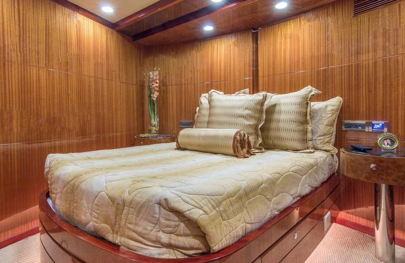 The stateroom features a luxurious bed with elegant bedding and warm wooden paneling. aboard ROBIN'S NEST Yacht for Sale