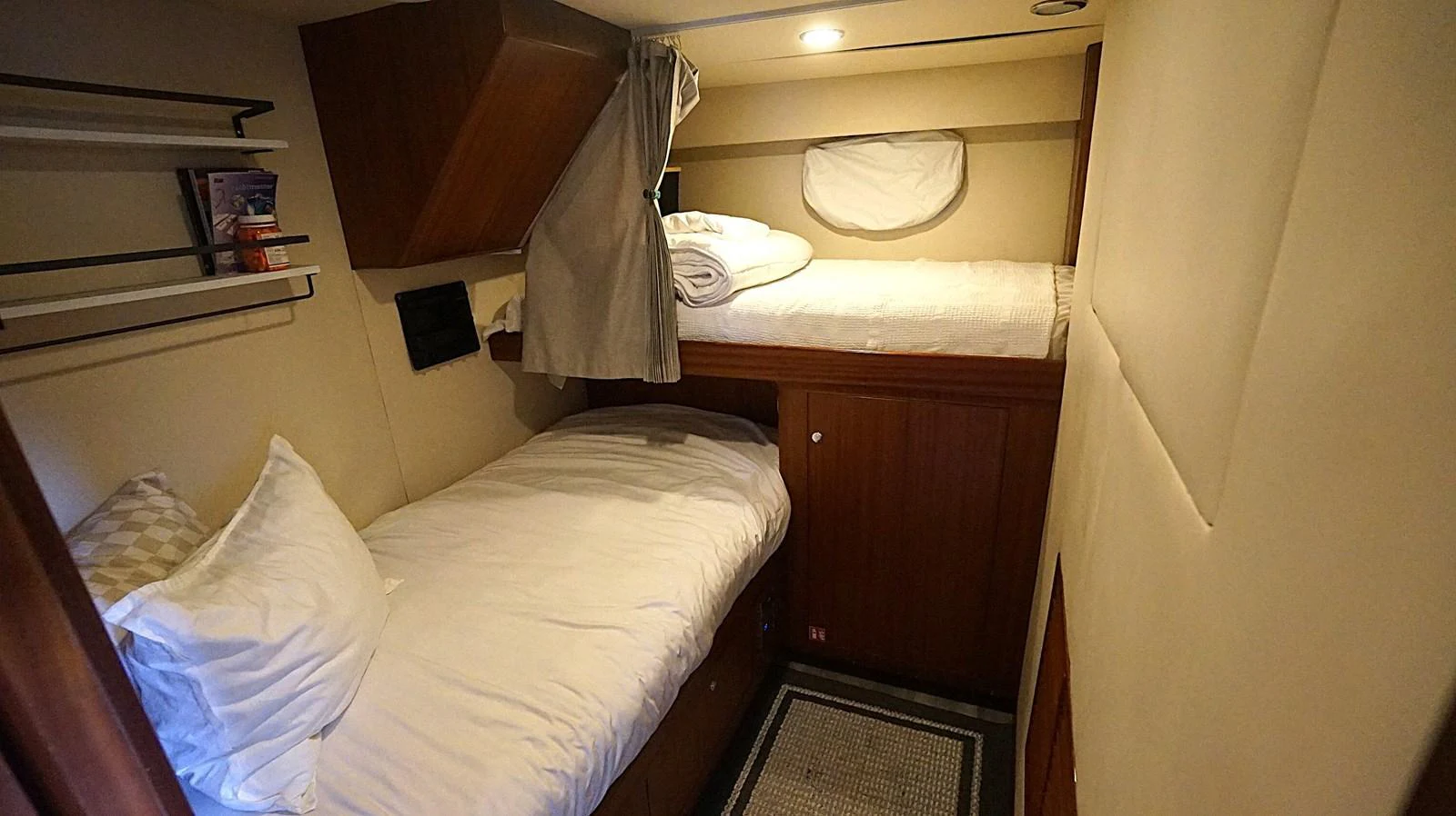 A cozy guest cabin featuring twin bunk beds and warm wooden accents. aboard ROBIN'S NEST Yacht for Sale