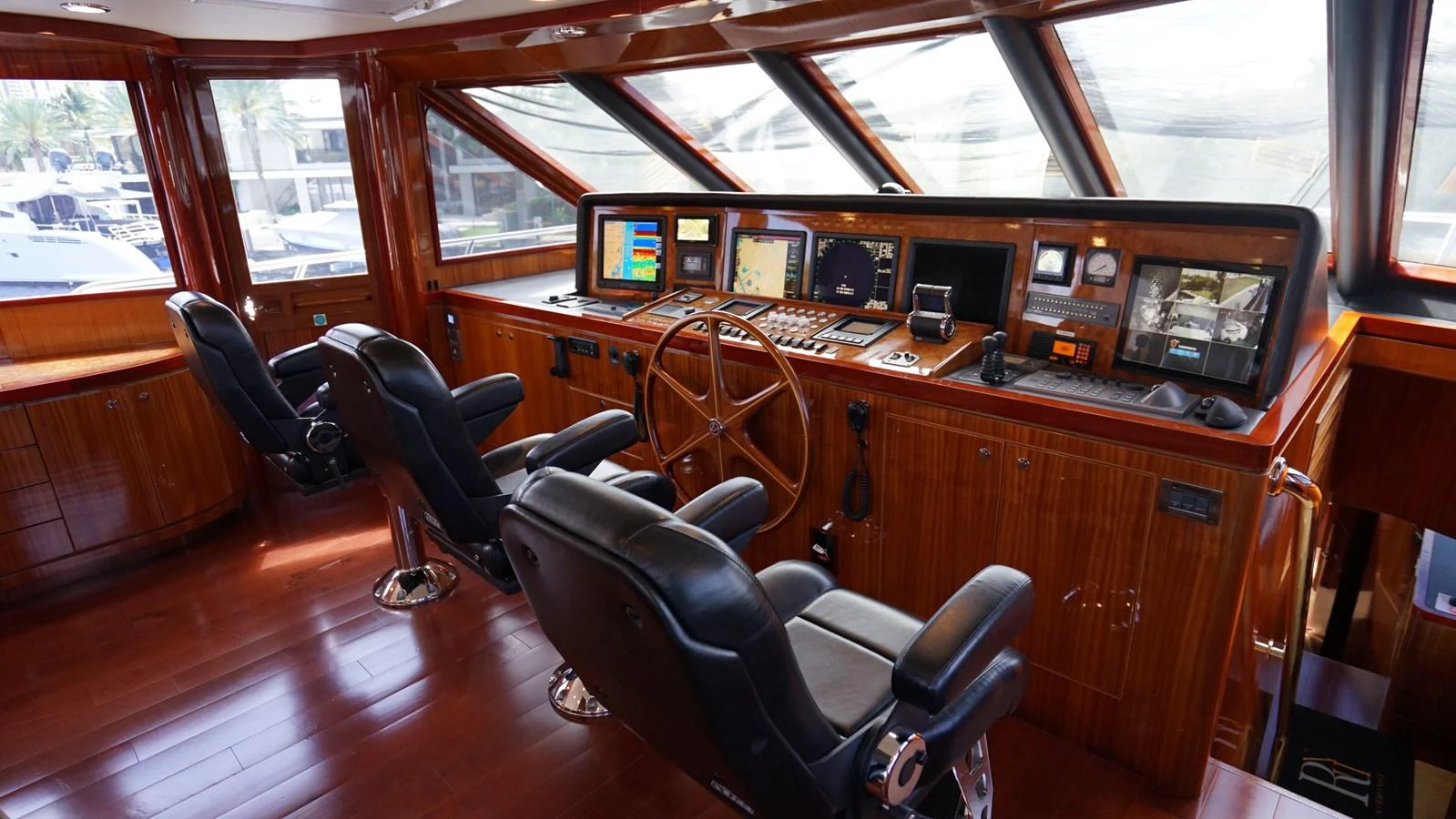 The helm station features a polished wooden finish with advanced navigation equipment and comfortable seating. aboard ROBIN'S NEST Yacht for Sale