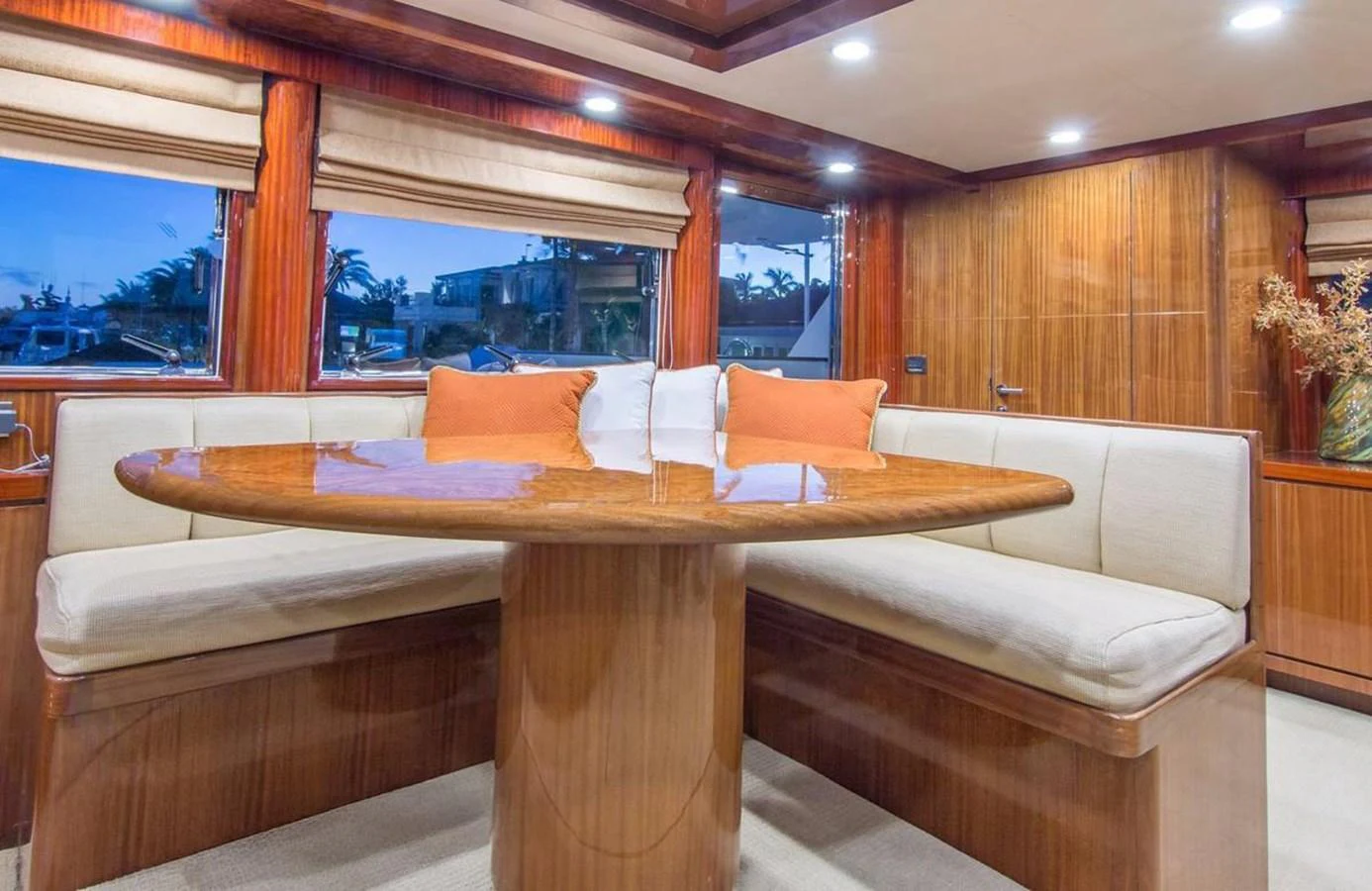 The yacht's dining area features a polished wooden table surrounded by comfortable upholstered seating, creating a warm and inviting space. aboard ROBIN'S NEST Yacht for Sale