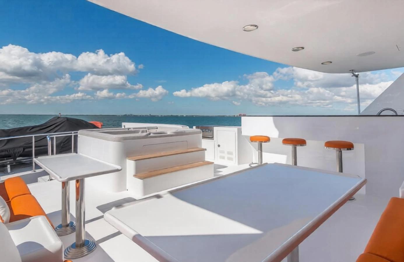 The sundeck offers a luxurious space with a hot tub, bar stools, and seating area, perfect for relaxation and entertainment. aboard ROBIN'S NEST Yacht for Sale