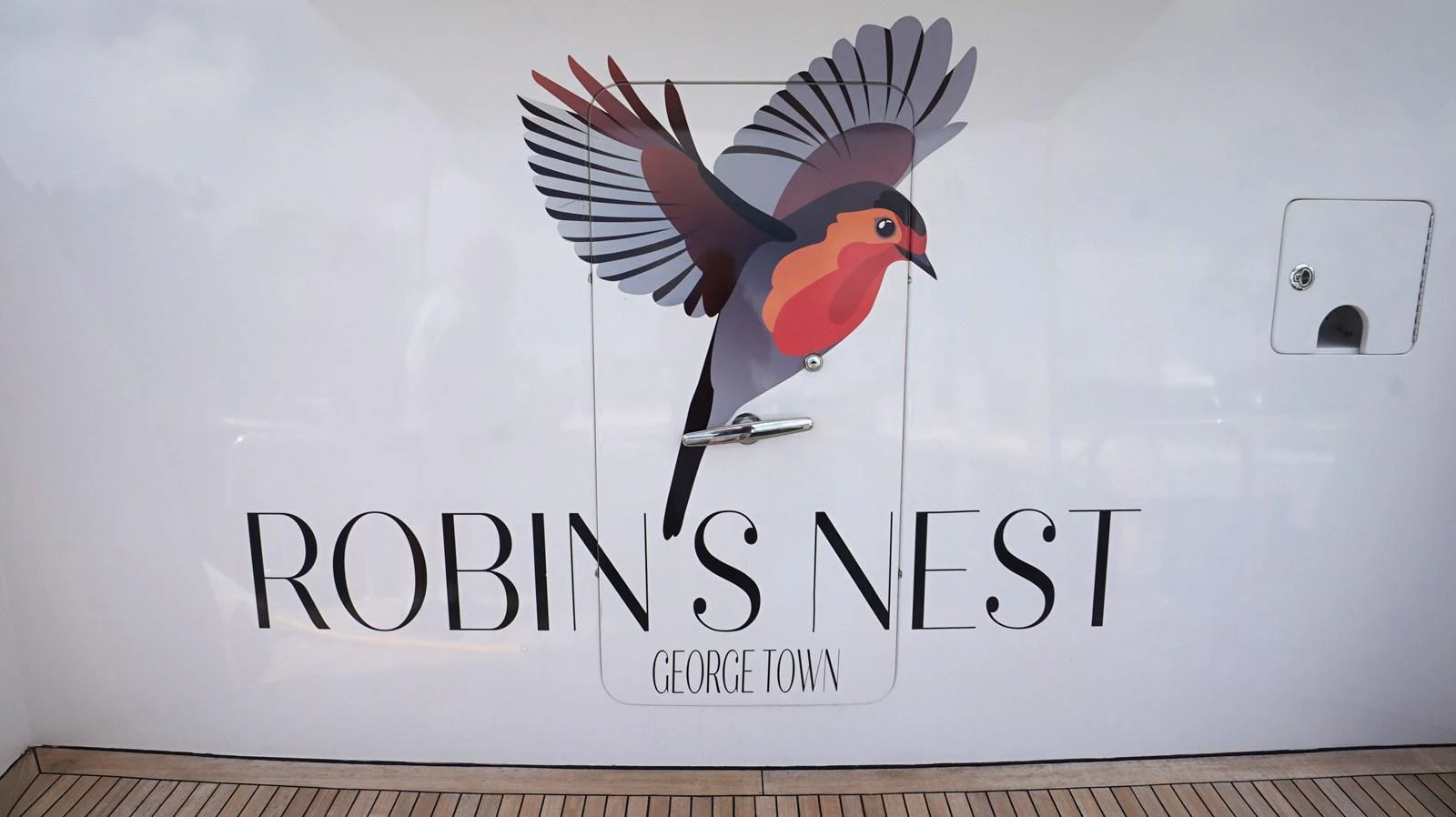 A close-up of the yacht's name and logo, featuring a colorful bird graphic. aboard ROBIN'S NEST Yacht for Sale