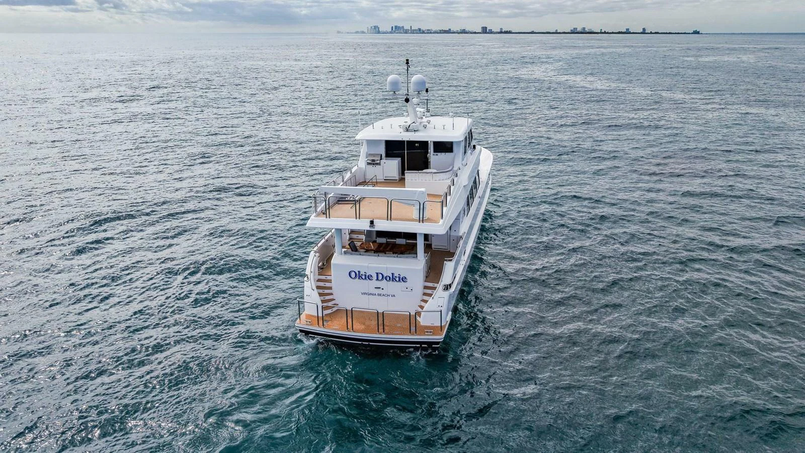 A luxurious yacht cruises on the open sea, showcasing its spacious aft deck and sleek design. aboard BOBBI TOO Yacht for Sale
