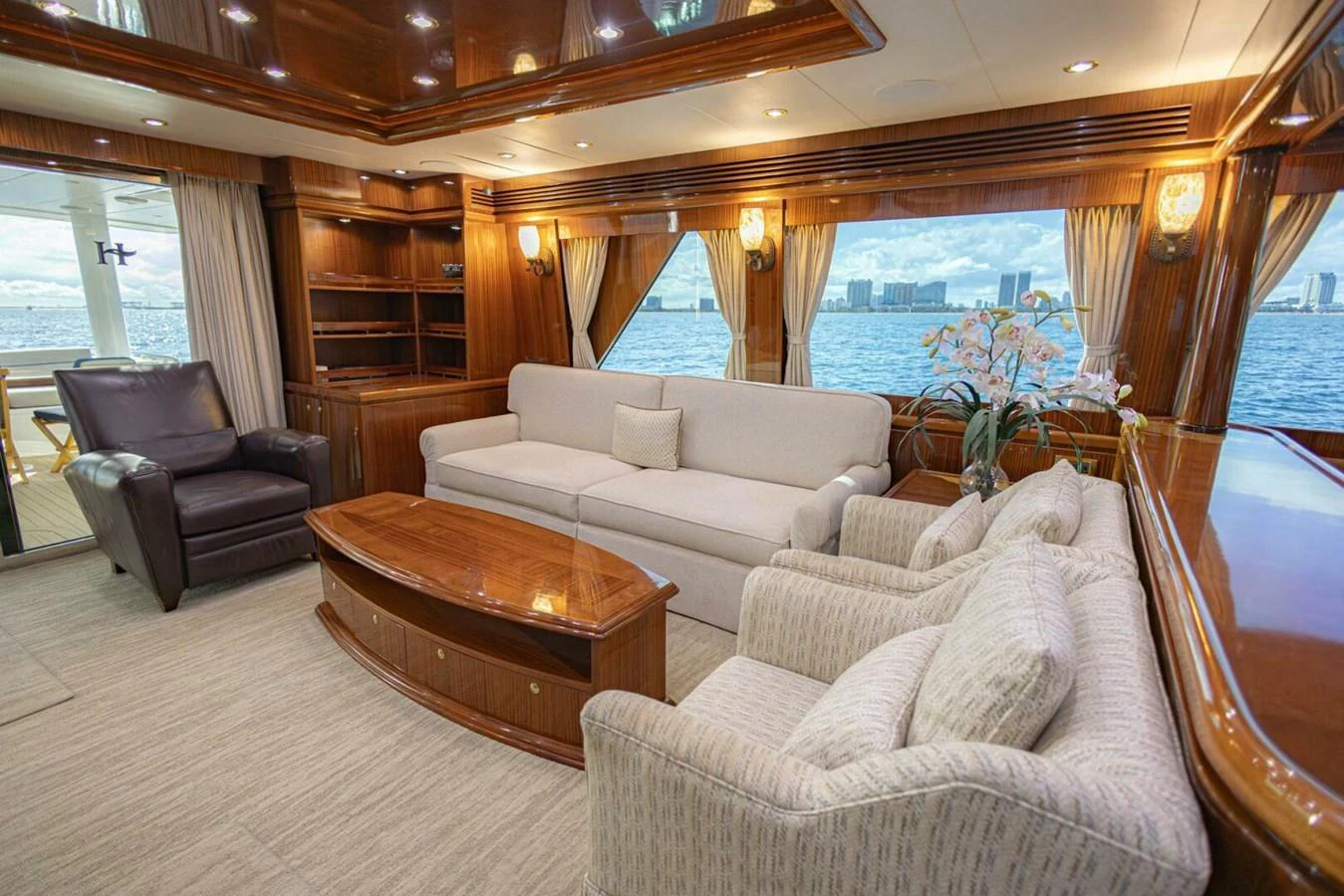 The salon features plush seating, elegant wood finishes, and large windows offering stunning water views. aboard BOBBI TOO Yacht for Sale