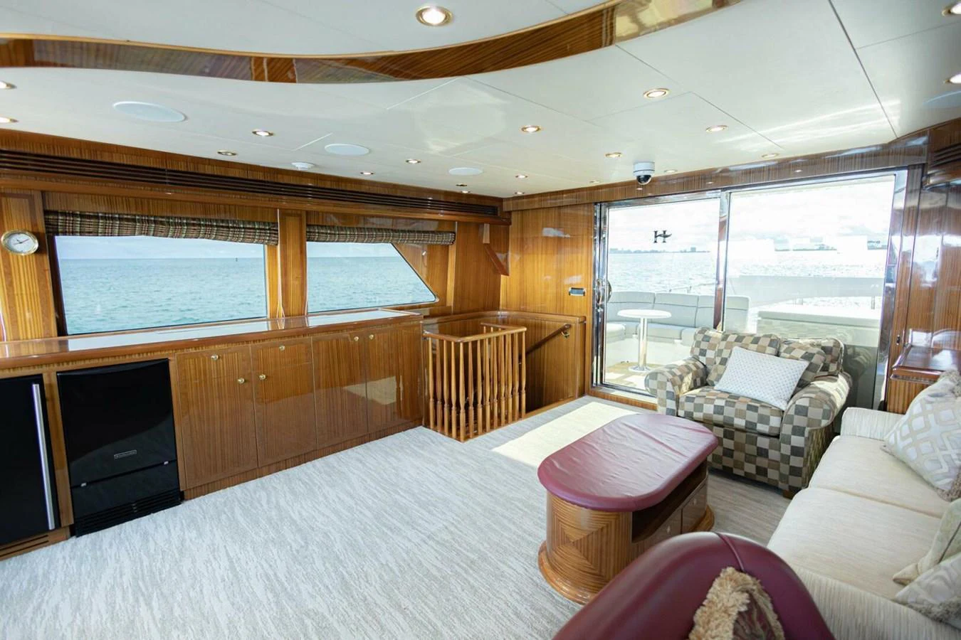 The yacht's interior features a spacious and well-lit living area with elegant wood finishes and comfortable seating. aboard BOBBI TOO Yacht for Sale
