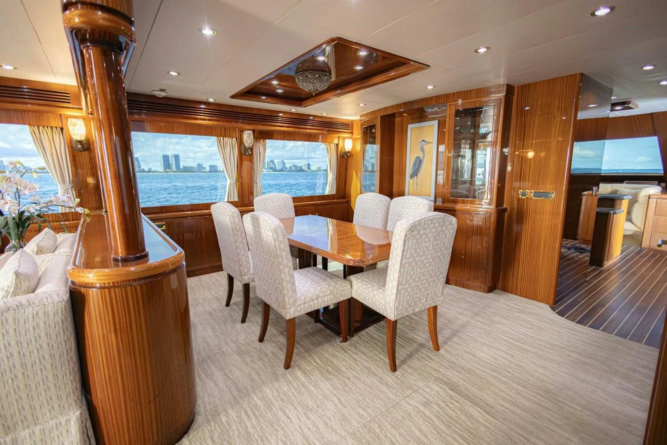 The yacht's dining area features elegant wood paneling and a large table with plush seating, offering a luxurious setting for meals with a view. aboard BOBBI TOO Yacht for Sale
