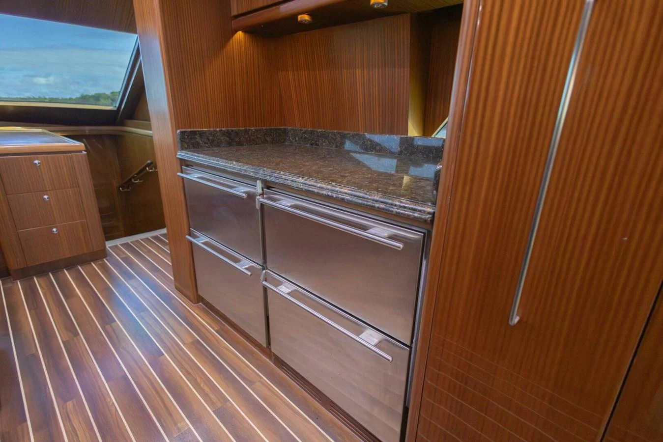 The yacht's galley features sleek wooden cabinetry and modern stainless steel appliances. aboard BOBBI TOO Yacht for Sale