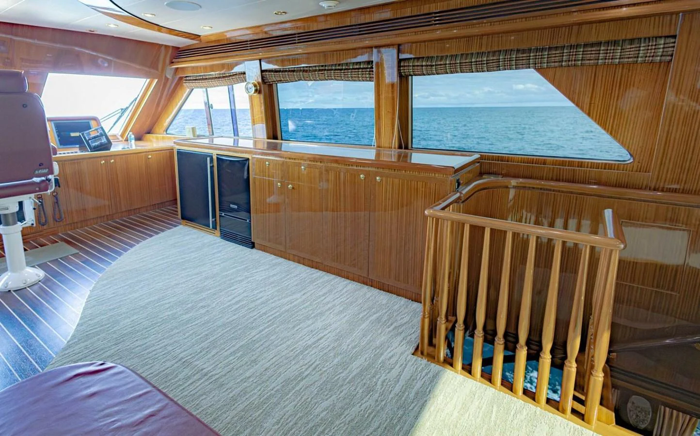 The salon features expansive windows offering stunning ocean views and elegant wooden finishes. aboard BOBBI TOO Yacht for Sale
