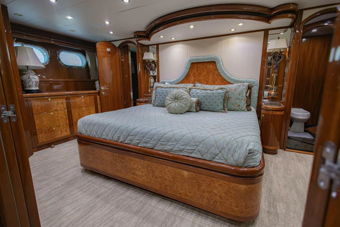 The master stateroom features a luxurious bed with elegant wood finishes and plush bedding. aboard BOBBI TOO Yacht for Sale