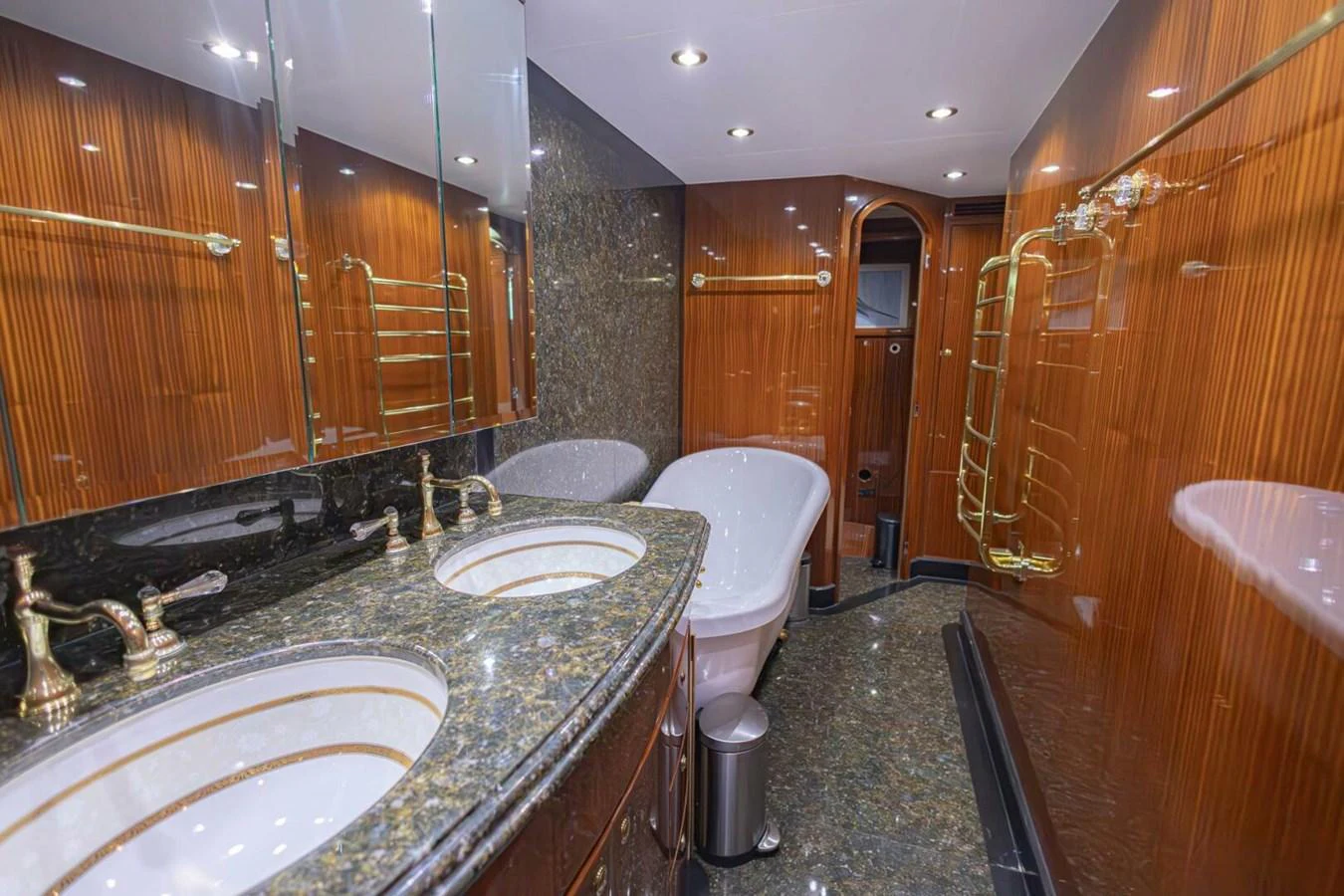 The yacht's bathroom features luxurious finishes with dual sinks, a bathtub, and elegant wood paneling. aboard BOBBI TOO Yacht for Sale