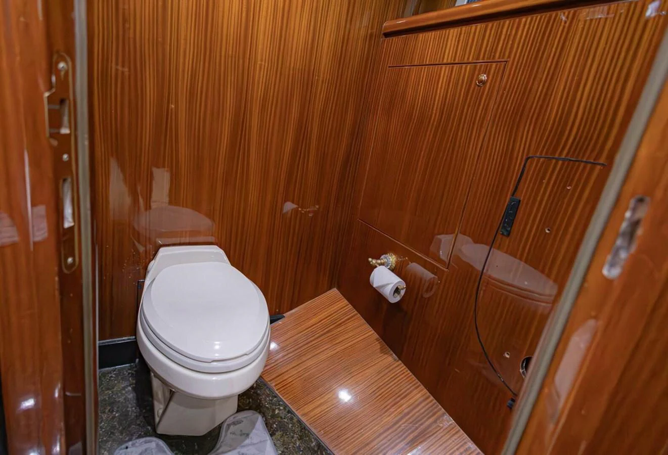 The yacht's head features elegant wood paneling and modern fixtures. aboard BOBBI TOO Yacht for Sale