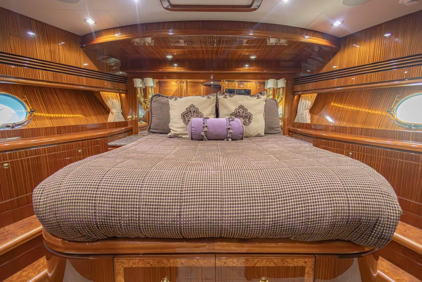 The master stateroom features luxurious wood paneling and a plush bed with elegant cushions. aboard BOBBI TOO Yacht for Sale