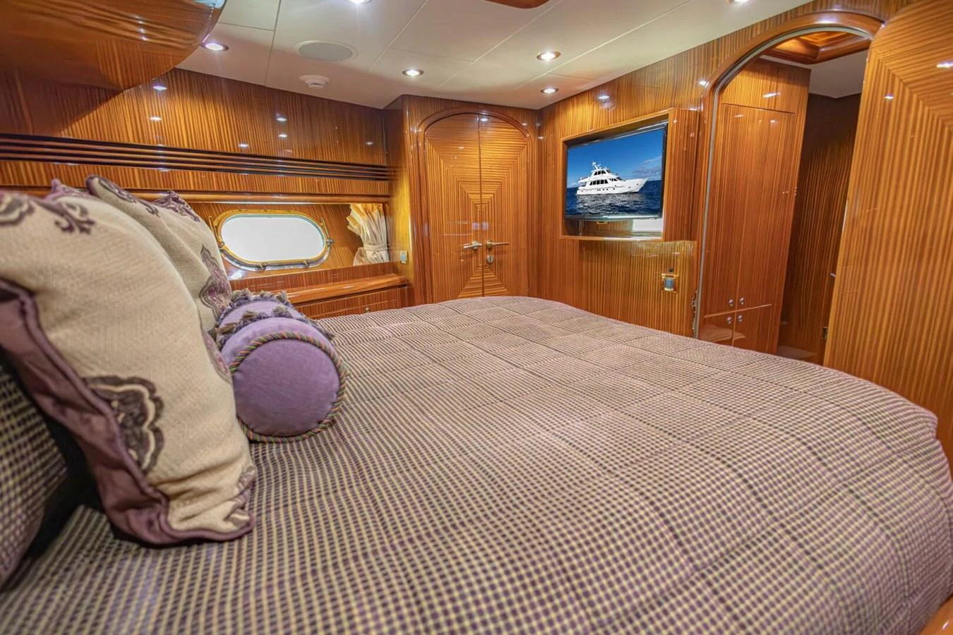 The stateroom features luxurious wood paneling and a comfortable bed with elegant bedding. aboard BOBBI TOO Yacht for Sale