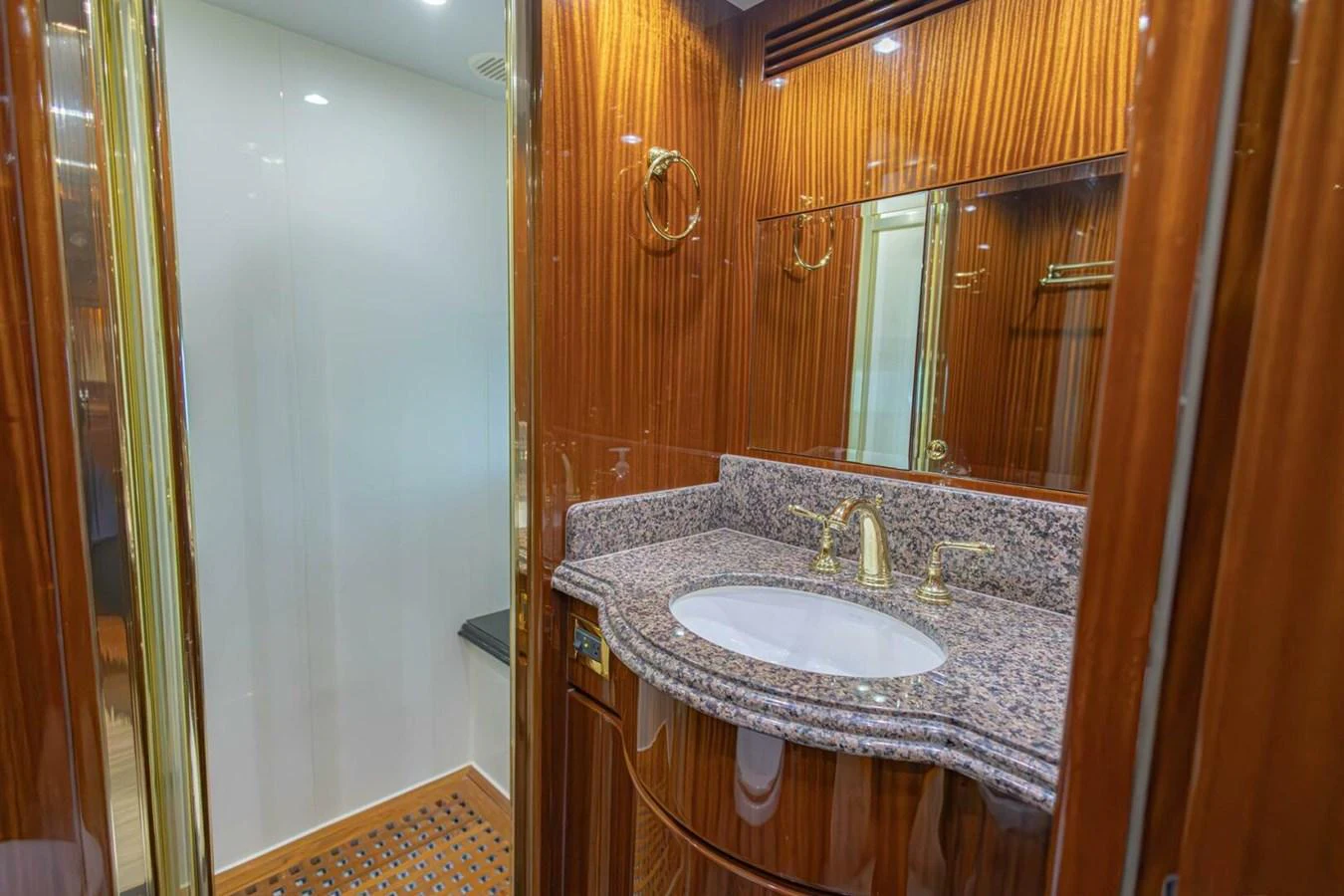 The yacht's bathroom features elegant wood paneling and a granite countertop. aboard BOBBI TOO Yacht for Sale