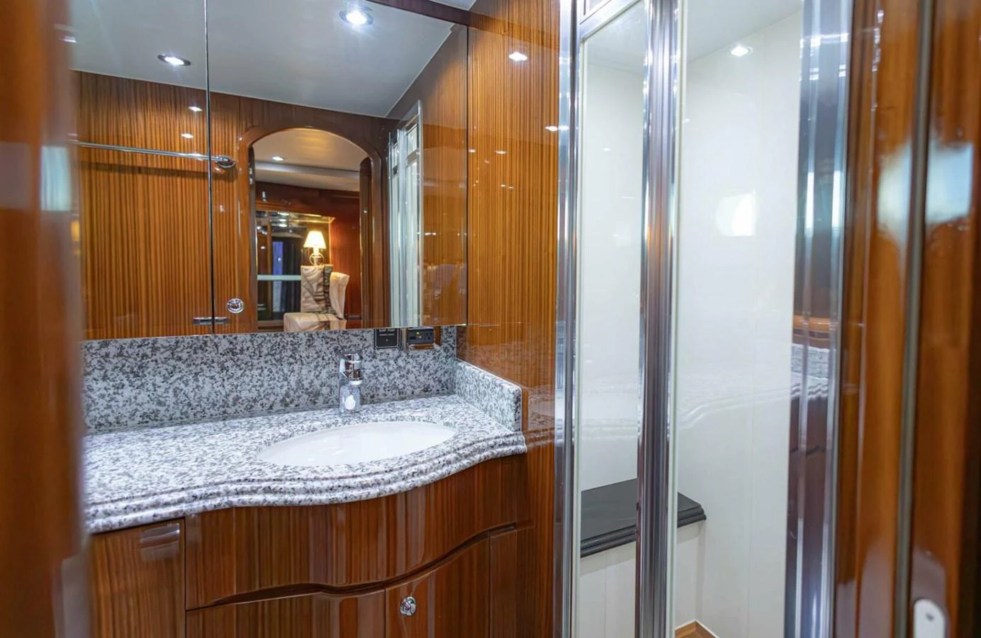 The yacht's bathroom features a sleek design with wooden paneling and a granite countertop. aboard BOBBI TOO Yacht for Sale