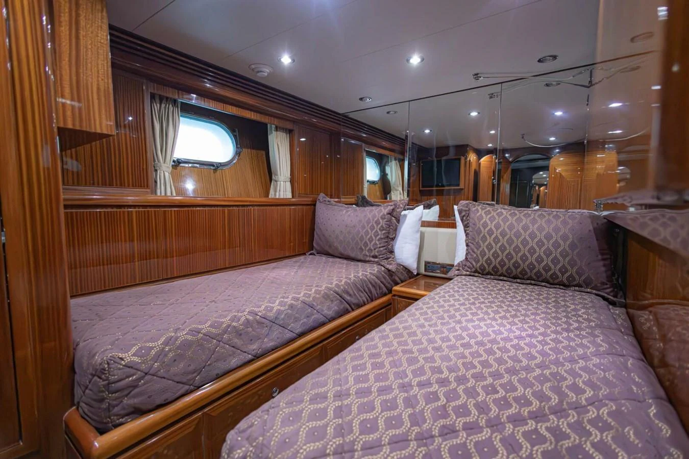 The twin stateroom features two comfortable beds with elegant bedding and rich wood paneling. aboard BOBBI TOO Yacht for Sale