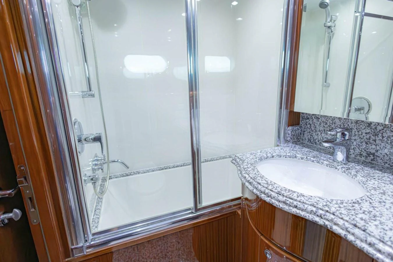 The yacht's bathroom features a sleek design with a granite countertop and a glass-enclosed shower. aboard BOBBI TOO Yacht for Sale