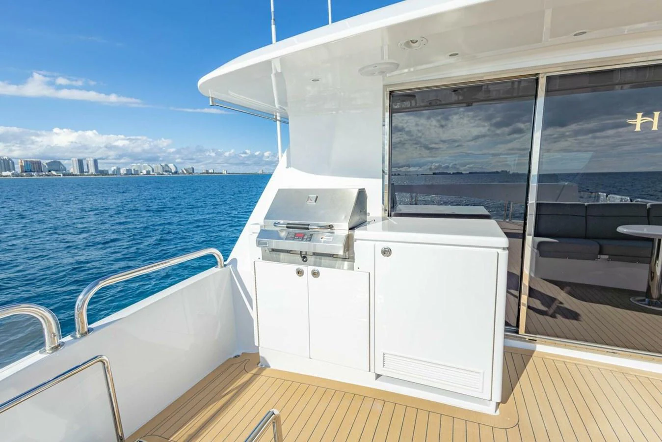 The aft deck features a sleek outdoor grill and cabinetry, perfect for alfresco dining with a stunning ocean view. aboard BOBBI TOO Yacht for Sale