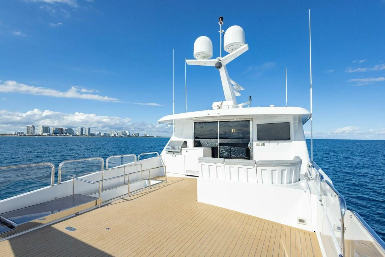 The spacious aft deck offers a stunning view of the open sea and city skyline. aboard BOBBI TOO Yacht for Sale